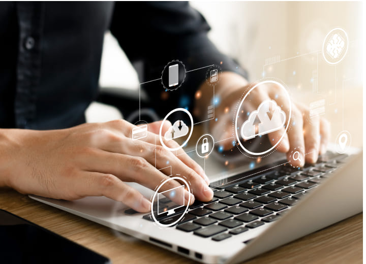 クラウドのアイコンと、パソコンで作業する手元の画像