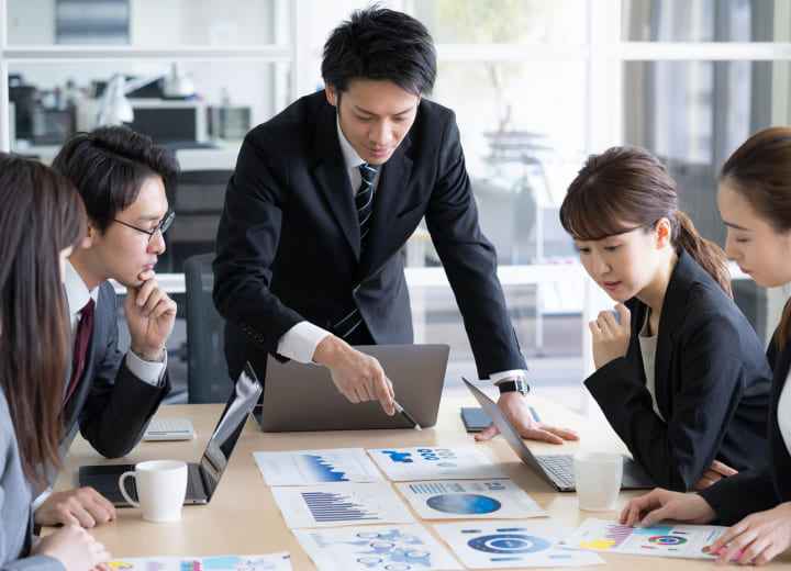 資料を見ながら会議をしている画像